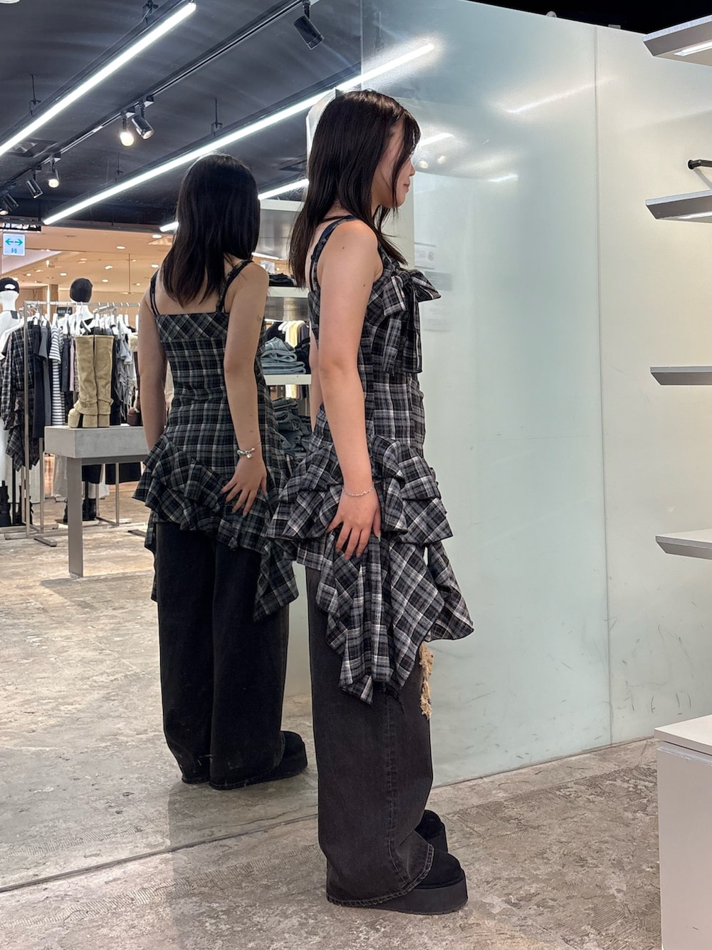 ブラック系のワンピース、ブラック系のデニムパンツ、ブラック系のスリッポンを着用したレディースの夏コーディネートの2枚目の写真