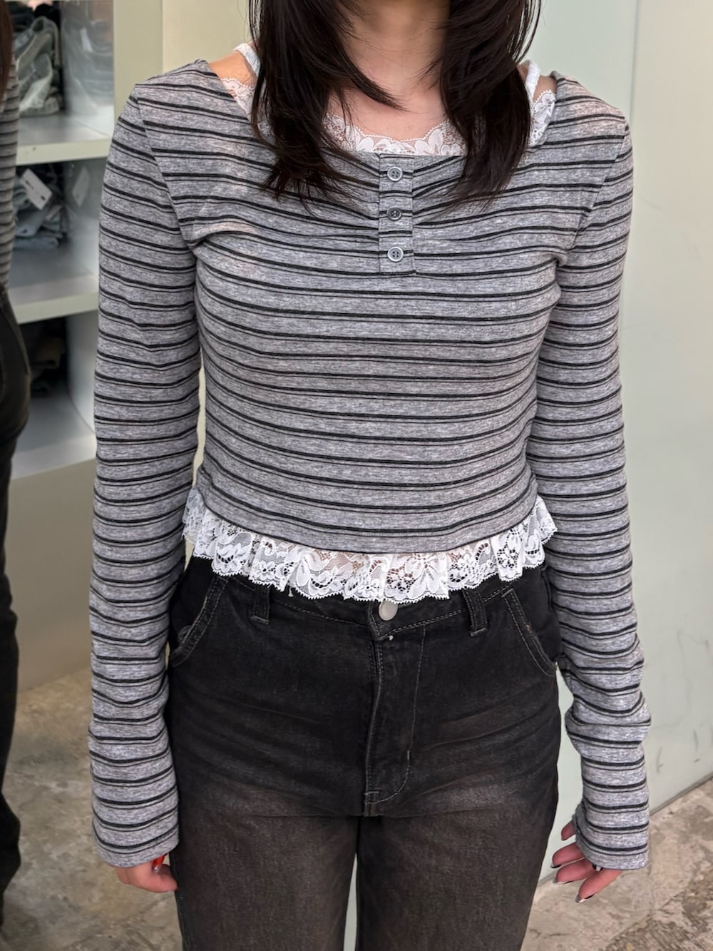 グレー系のTシャツ/カットソー、ブラック系のデニムパンツ、ブラック系のスリッポンを着用したレディースの秋コーディネートの4枚目の写真