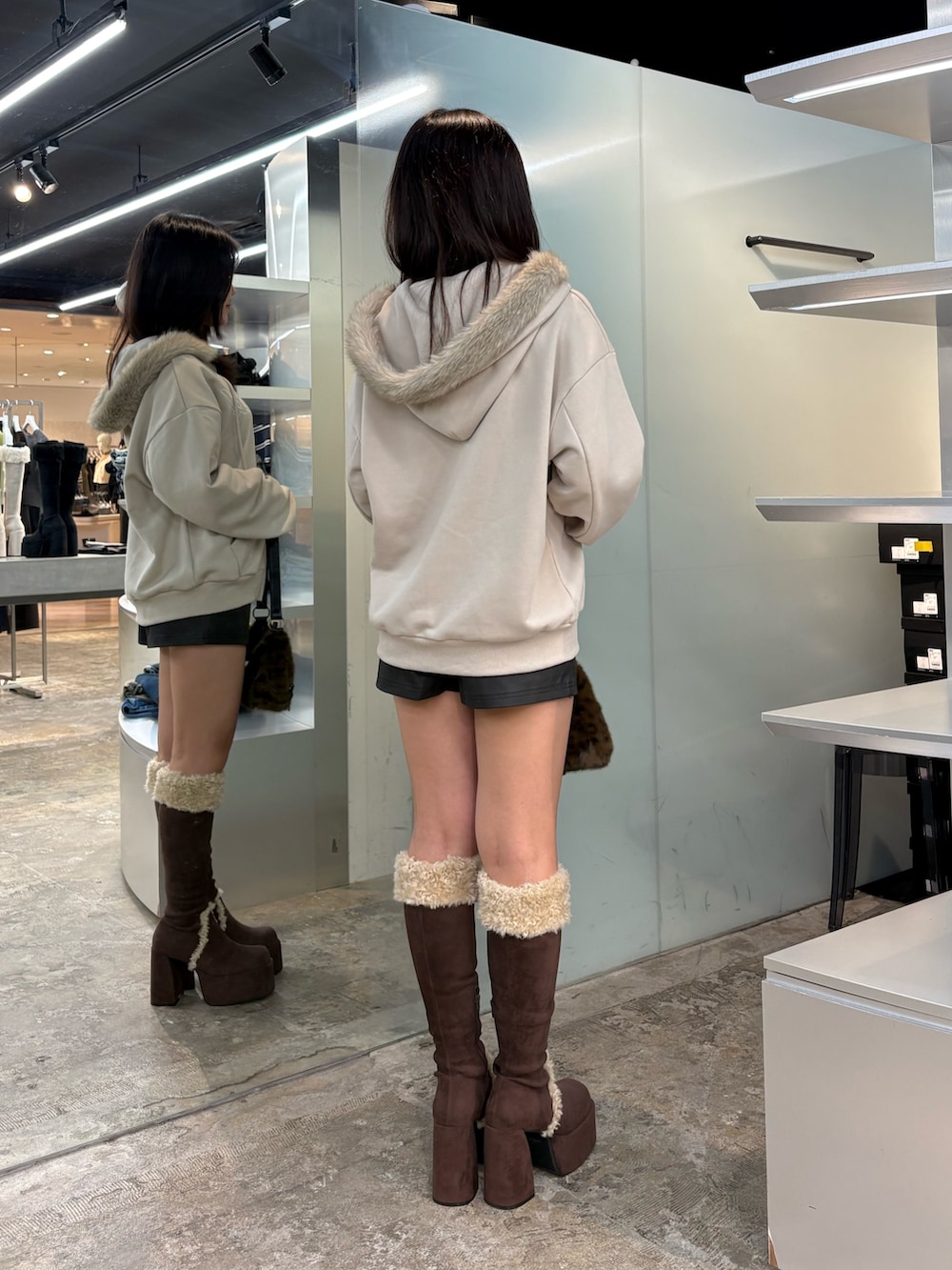 ブラウン系のブーツ、ベージュ系のパーカー、ブラック系のその他パンツを着用したレディースの秋コーディネートの3枚目の写真