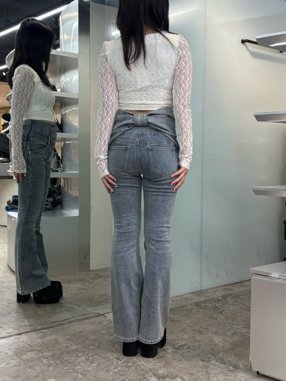 ホワイト系のTシャツ/カットソー、ブルー系のデニムパンツ、ブラック系のブーツを着用したレディースの秋コーディネートの3枚目の写真