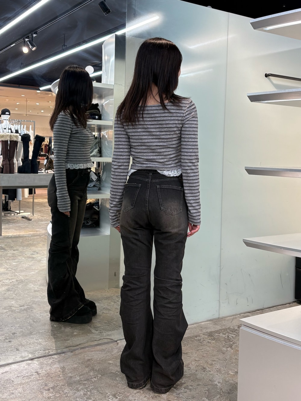 グレー系のTシャツ/カットソー、ブラック系のデニムパンツ、ブラック系のスリッポンを着用したレディースの秋コーディネートの3枚目の写真