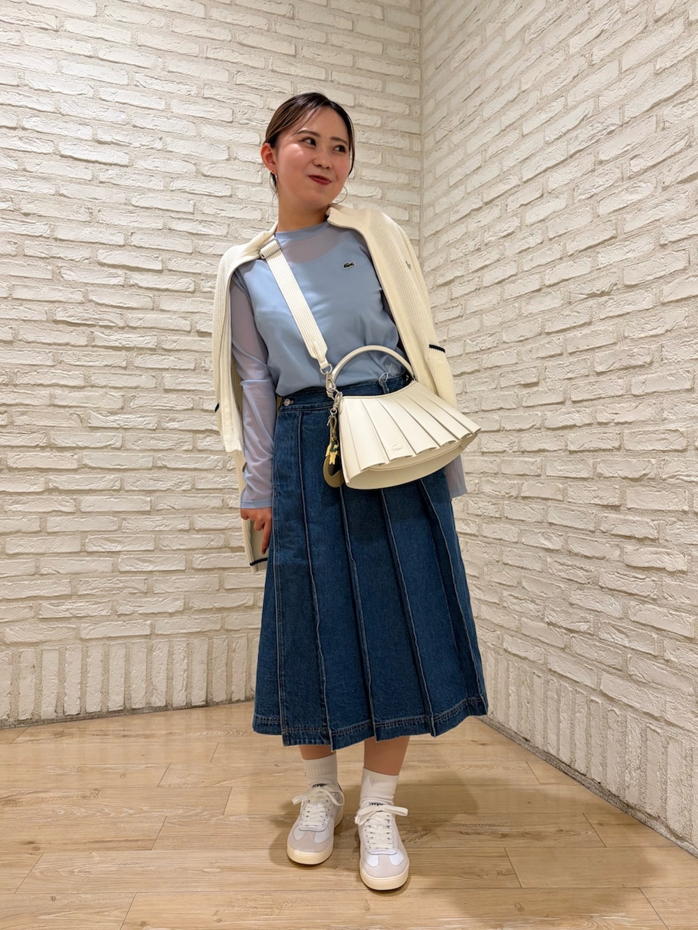 ブルー系のスカート、ブルー系のTシャツ/カットソー、ホワイト系のカーディガン/ボレロを着用したレディースの春コーディネートの2枚目の写真