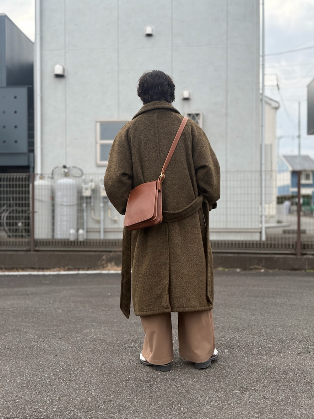 ブラウン系のシューズ、ブラウン系のスラックス、ブラウン系のステンカラーコートを着用したメンズの冬コーディネートの3枚目の写真