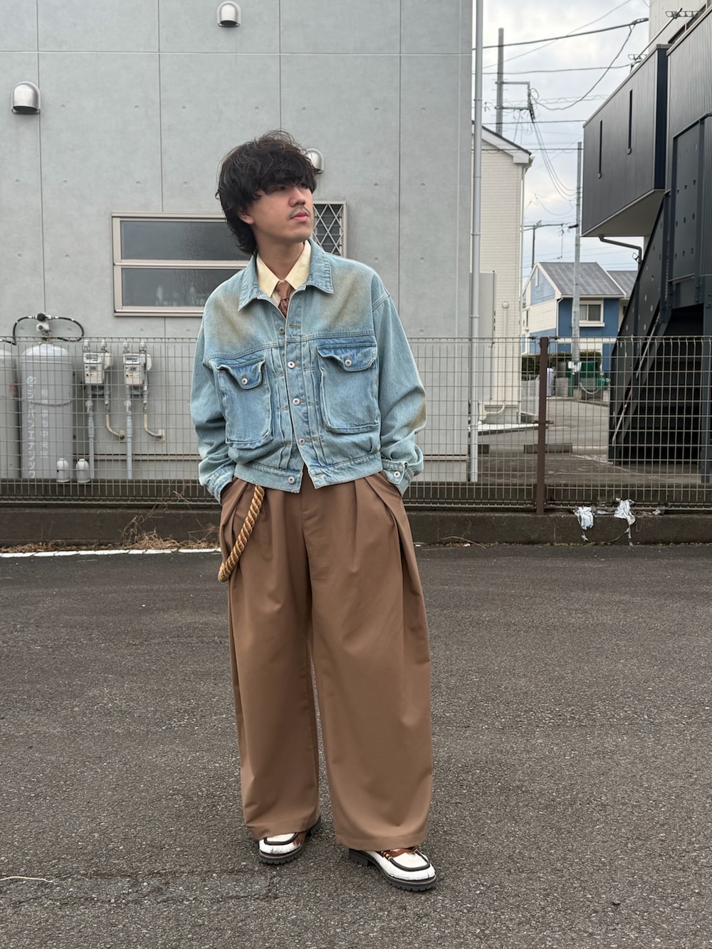 ブラウン系のシューズ、ブラウン系のスラックス、ブラウン系のステンカラーコートを着用したメンズの冬コーディネートの4枚目の写真