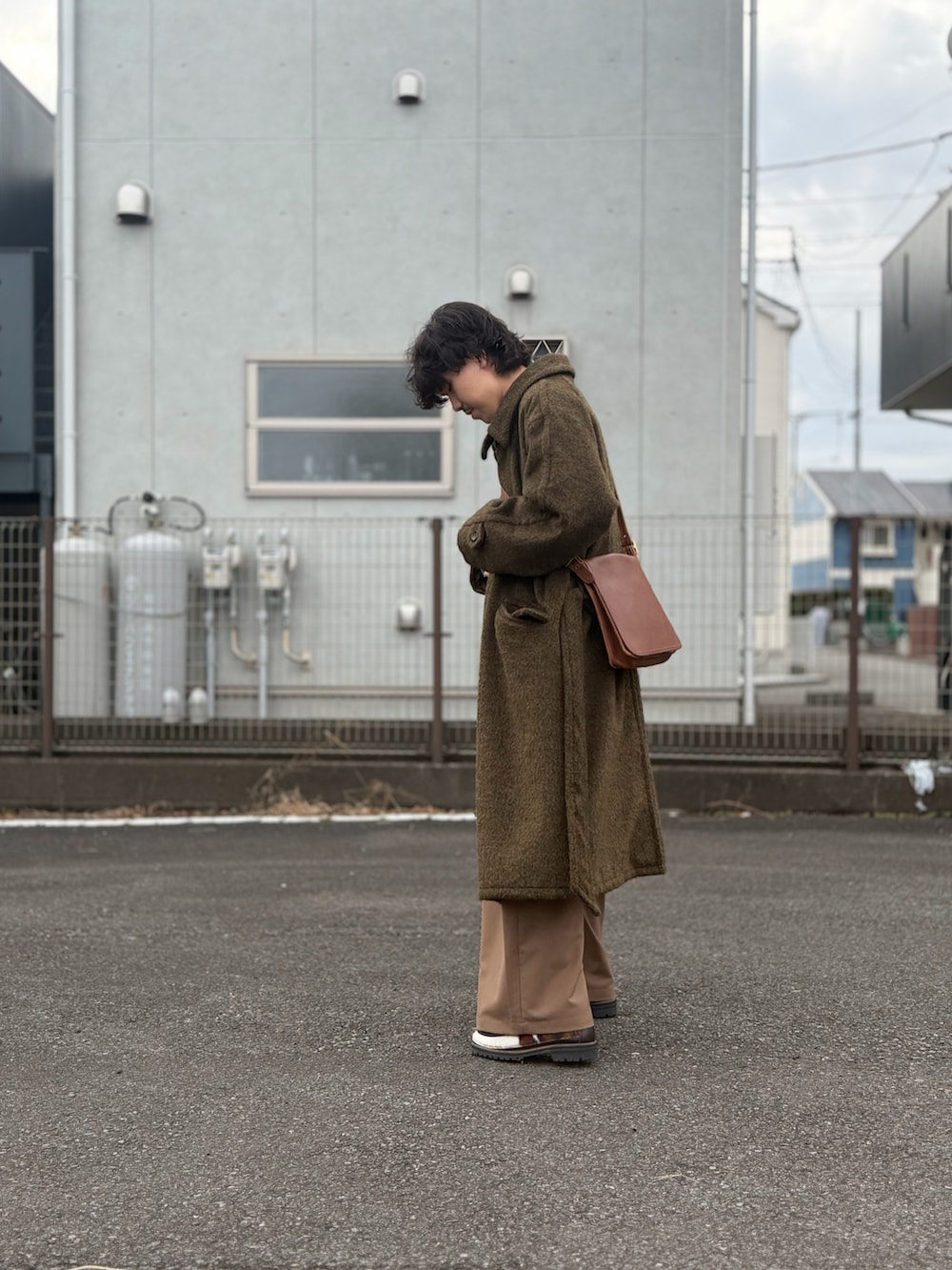 ブラウン系のシューズ、ブラウン系のスラックス、ブラウン系のステンカラーコートを着用したメンズの冬コーディネートの2枚目の写真