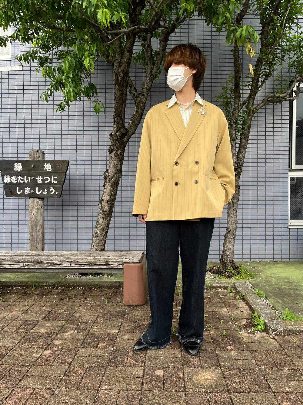 ブラック系のドレスシューズ、ブルー系のデニムパンツ、イエロー系のテーラードジャケットを着用したメンズの春コーディネートの2枚目の写真