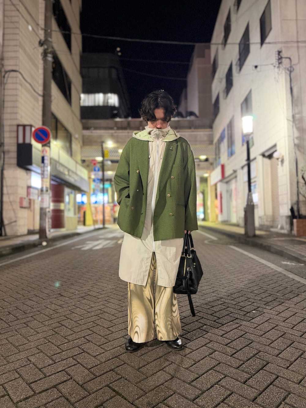 ベージュ系のTシャツ/カットソー、グリーン系のテーラードジャケット、グリーン系のスラックスを着用したメンズの春コーディネートの2枚目の写真