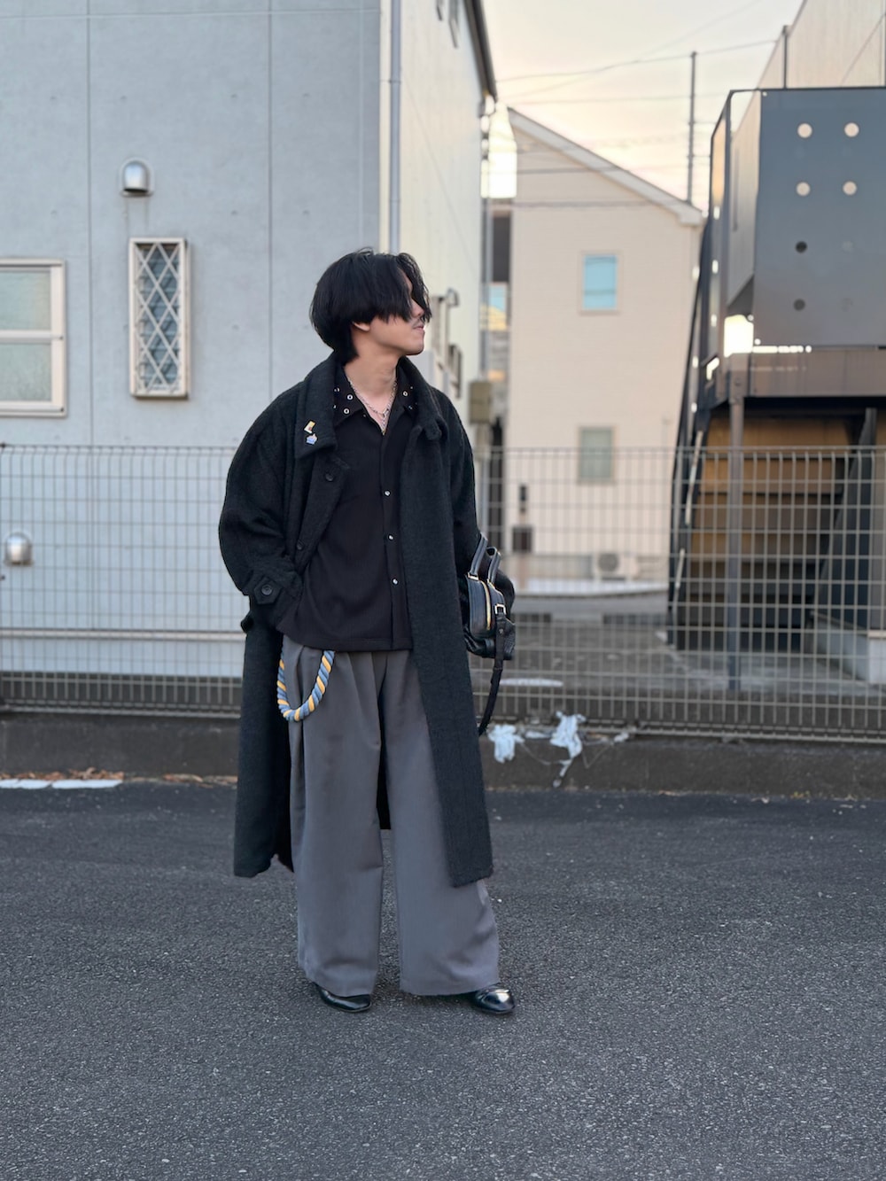 ブラック系のドレスシューズ、グレー系のスラックス、ブラック系のシャツ/ブラウスを着用したメンズの冬コーディネートの2枚目の写真