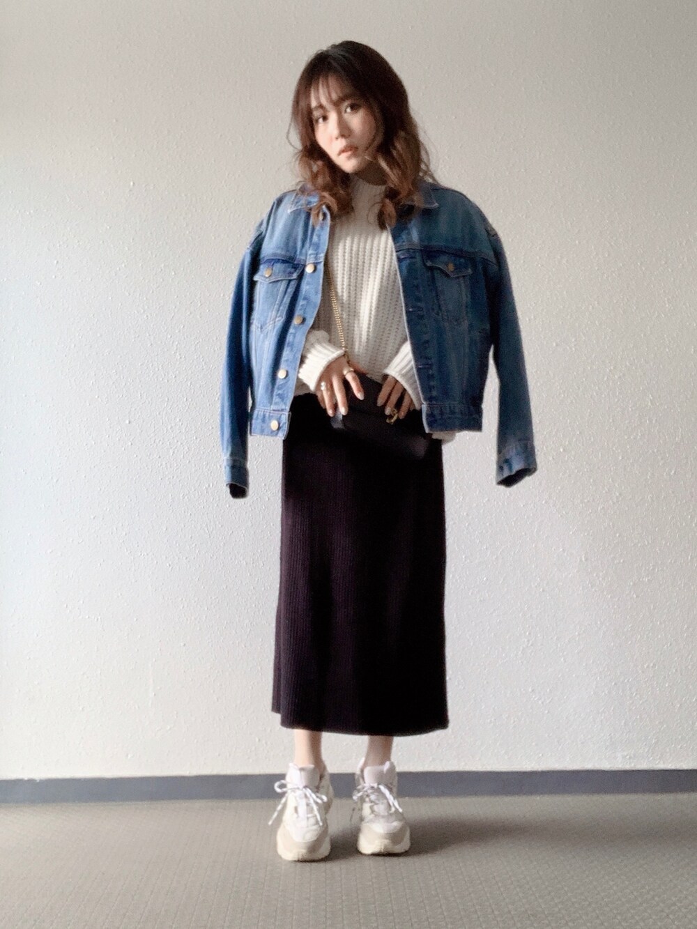 ホワイト系のニット/セーター、ブラック系のショルダーバッグ、ブラック系のスカートを着用したレディースの冬コーディネートの2枚目の写真