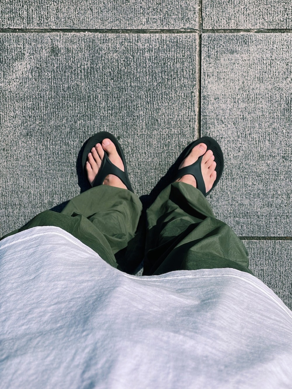 グリーン系のその他パンツ、ブラック系のサンダル、ホワイト系のTシャツ/カットソーを着用したメンズの夏コーディネートの2枚目の写真