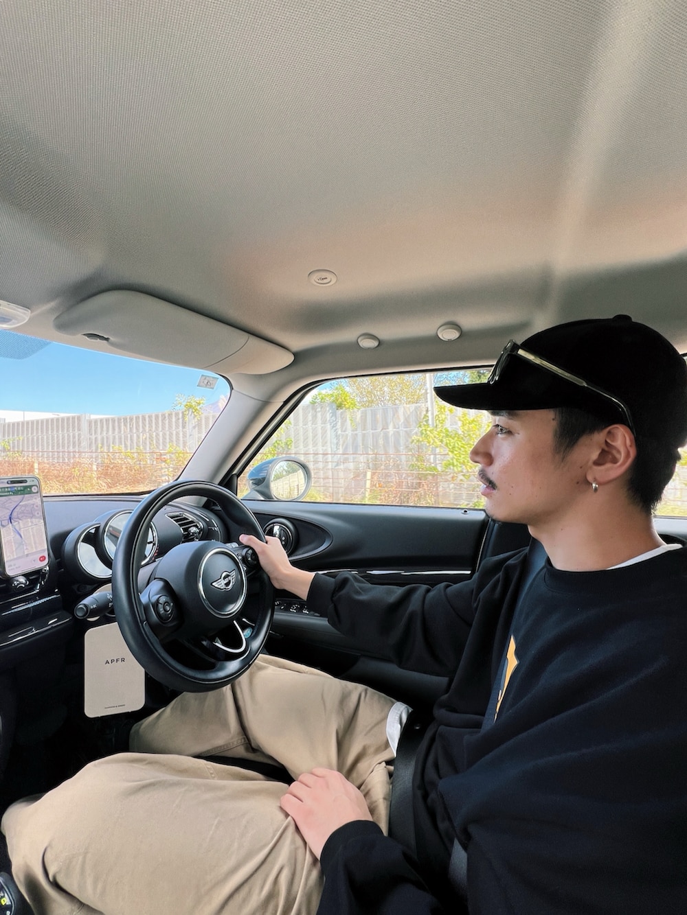 ブラック系のスウェット、ベージュ系のチノパンツを着用したメンズの冬コーディネートの3枚目の写真