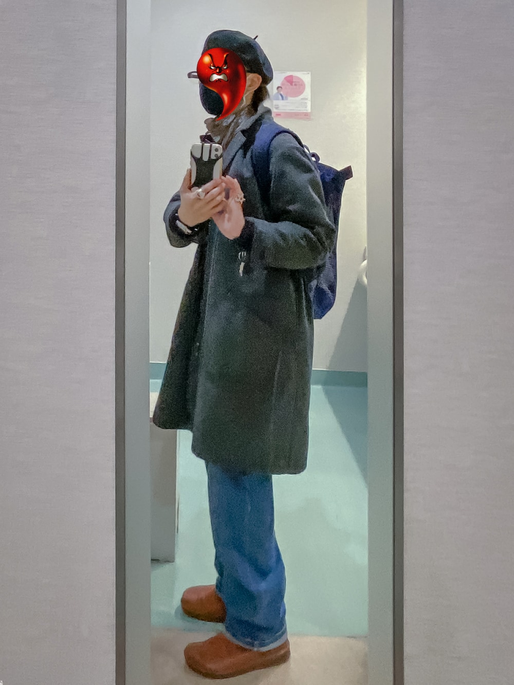 グレー系のチェスターコート、ブルー系のサロペット/オーバーオール、ブルー系のバックパック/リュックを着用したメンズの春コーディネートの2枚目の写真