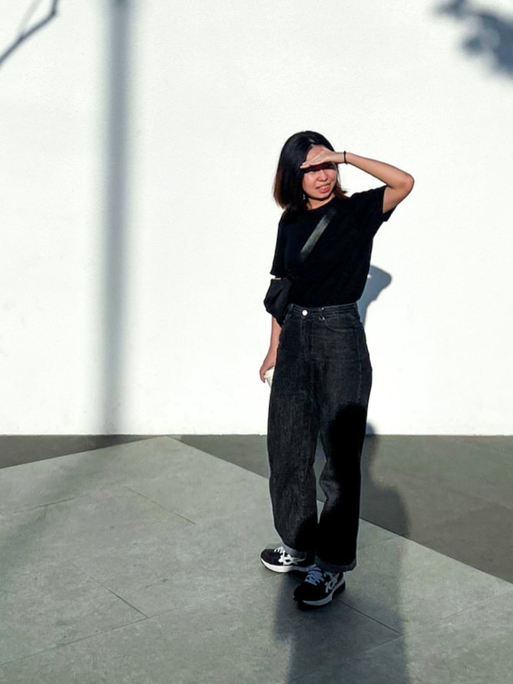 ブラック系のパンツ、ブラック系のTシャツ/カットソー、ブラック系のスニーカーを着用したレディースの春コーディネートの2枚目の写真