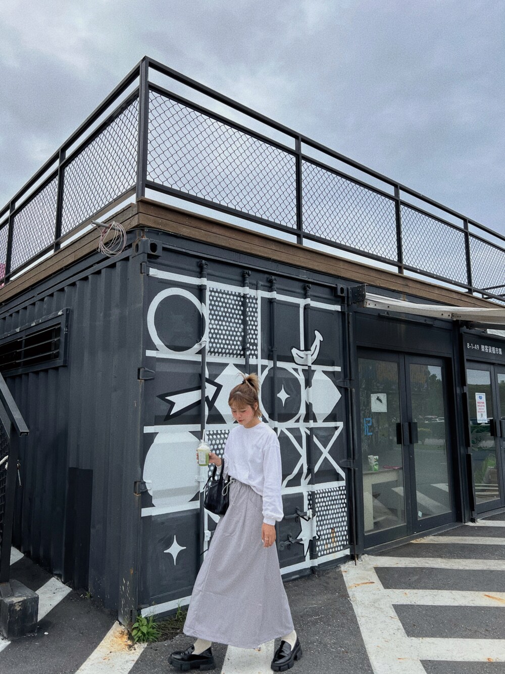 ブラック系のバッグを着用したレディースの秋コーディネートの2枚目の写真