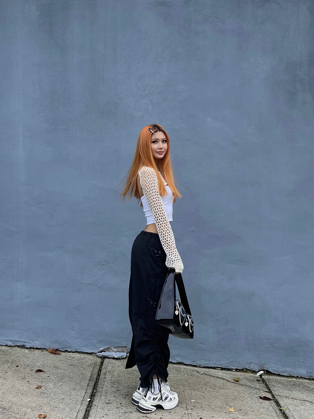 ブラック系のスカート、ブラック系のショルダーバッグを着用したレディースの秋コーディネートの2枚目の写真