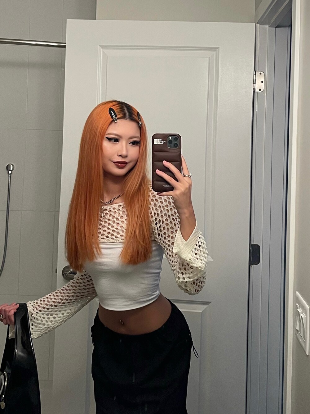 ブラック系のスカート、ブラック系のショルダーバッグを着用したレディースの秋コーディネートの3枚目の写真