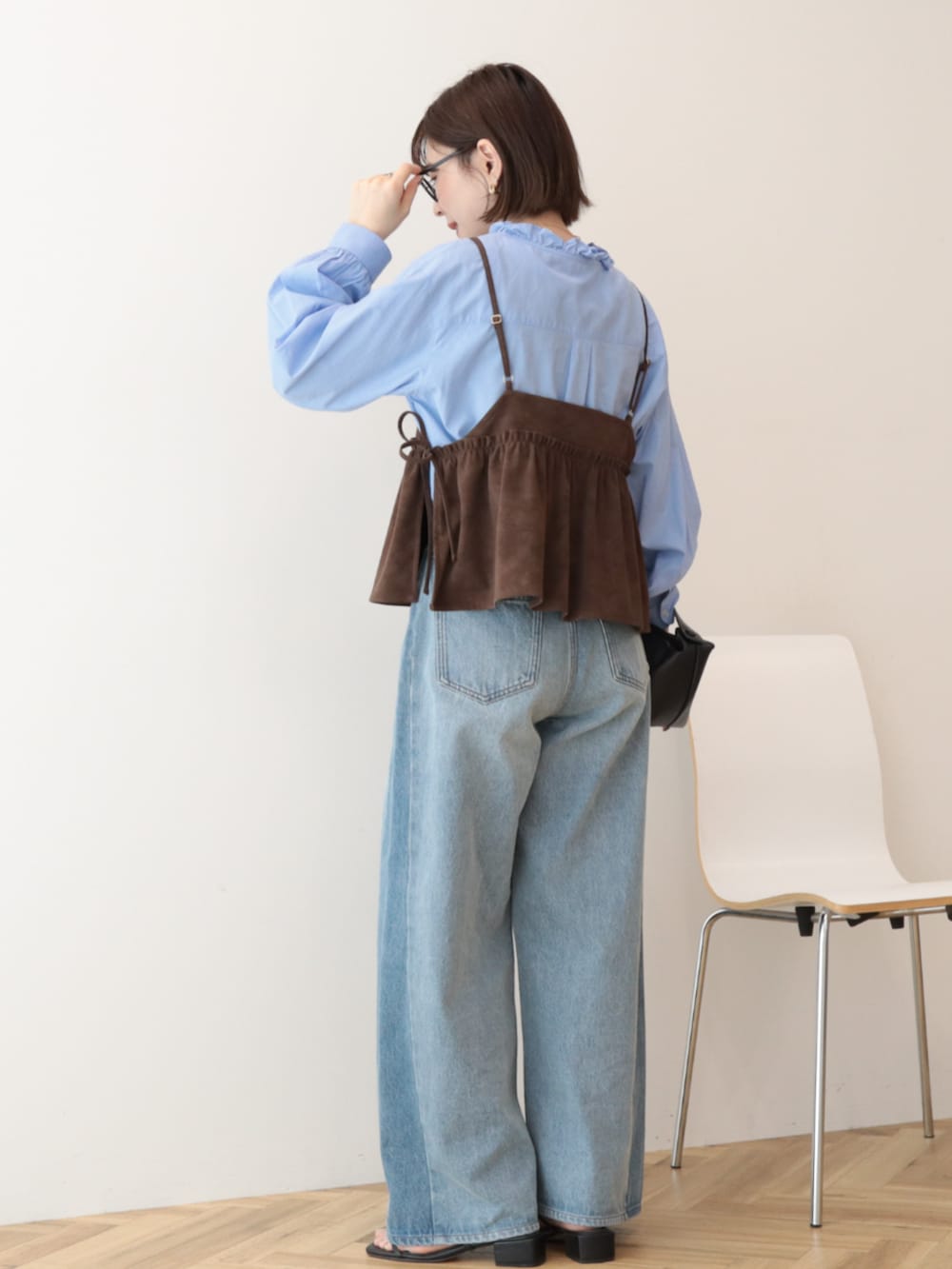 ブルー系のシャツ/ブラウス、ブラウン系のベスト、ブルー系のデニムパンツを着用したレディースの冬コーディネートの2枚目の写真