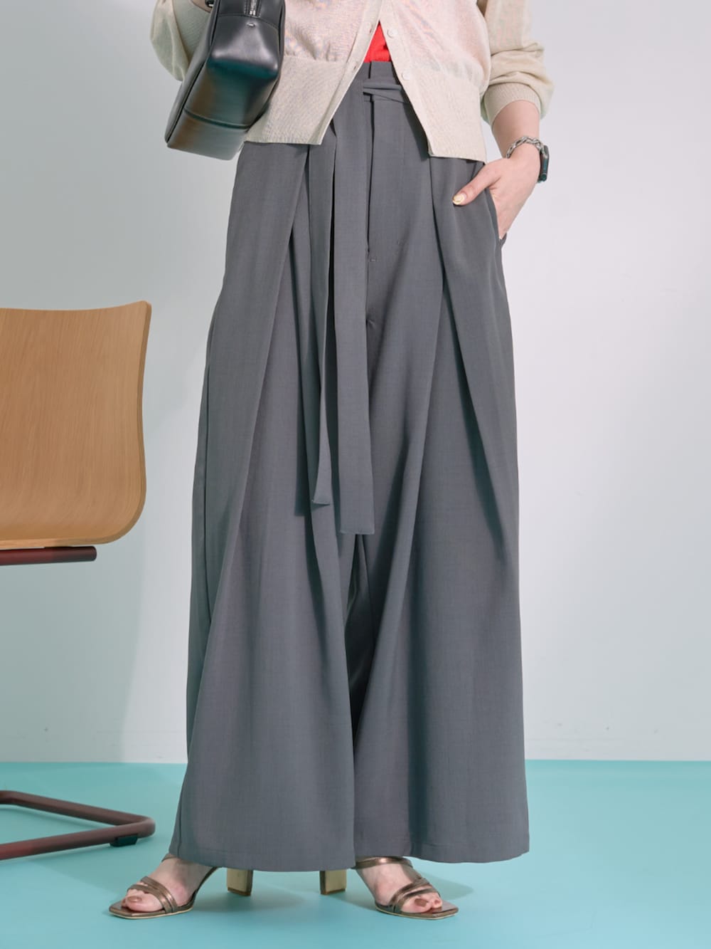 グレー系のその他パンツ、ベージュ系のカーディガン/ボレロ、ブラック系のショルダーバッグを着用したレディースの夏コーディネートの4枚目の写真