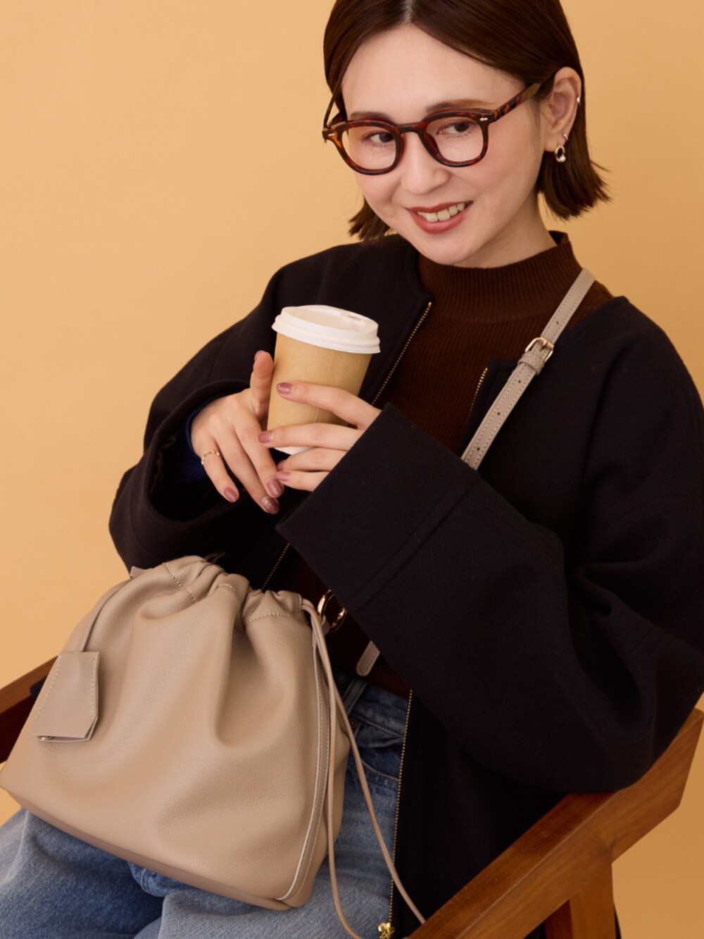 ブルー系のデニムパンツ、ブラック系のその他アウター、ブラウン系のニット/セーターを着用したレディースの冬コーディネートの4枚目の写真