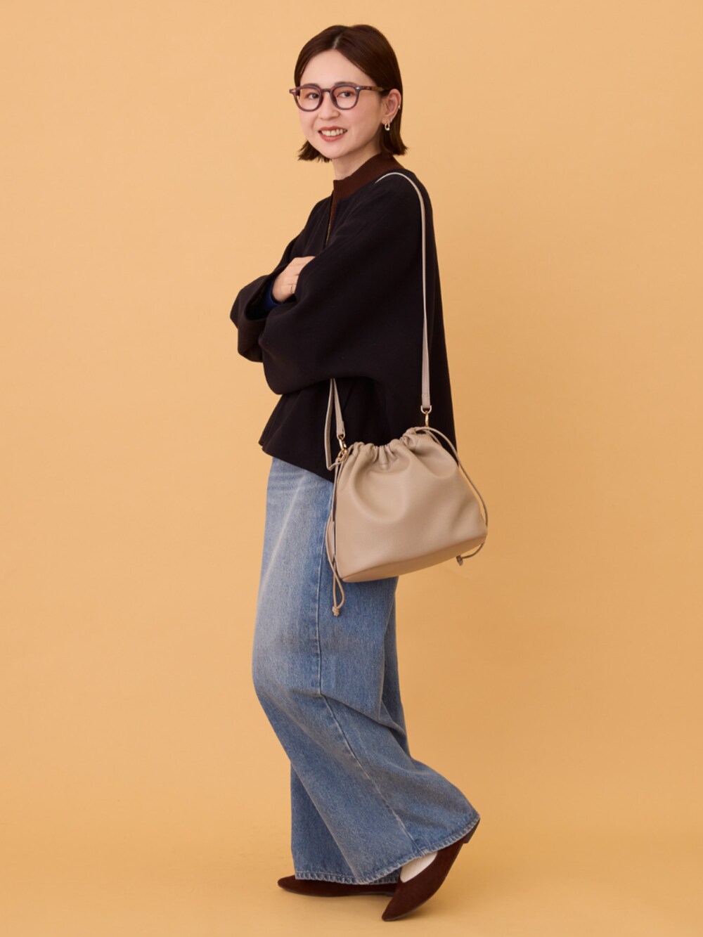 ブルー系のデニムパンツ、ブラック系のその他アウター、ブラウン系のニット/セーターを着用したレディースの冬コーディネートの2枚目の写真
