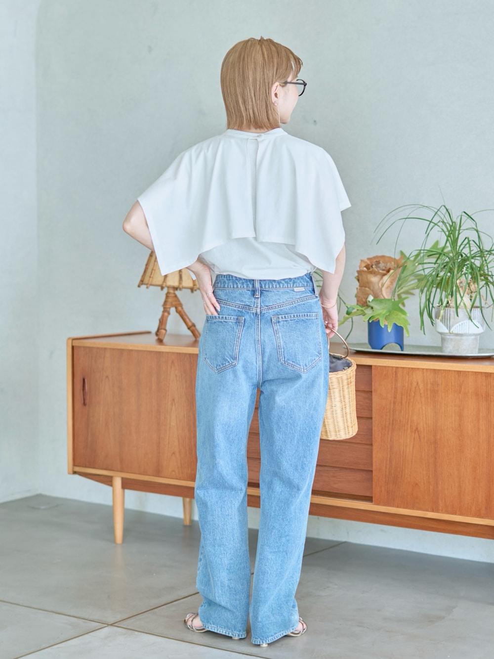 ブルー系のデニムパンツ、ホワイト系のTシャツ/カットソー、グレー系のサンダルを着用したレディースの夏コーディネートの3枚目の写真