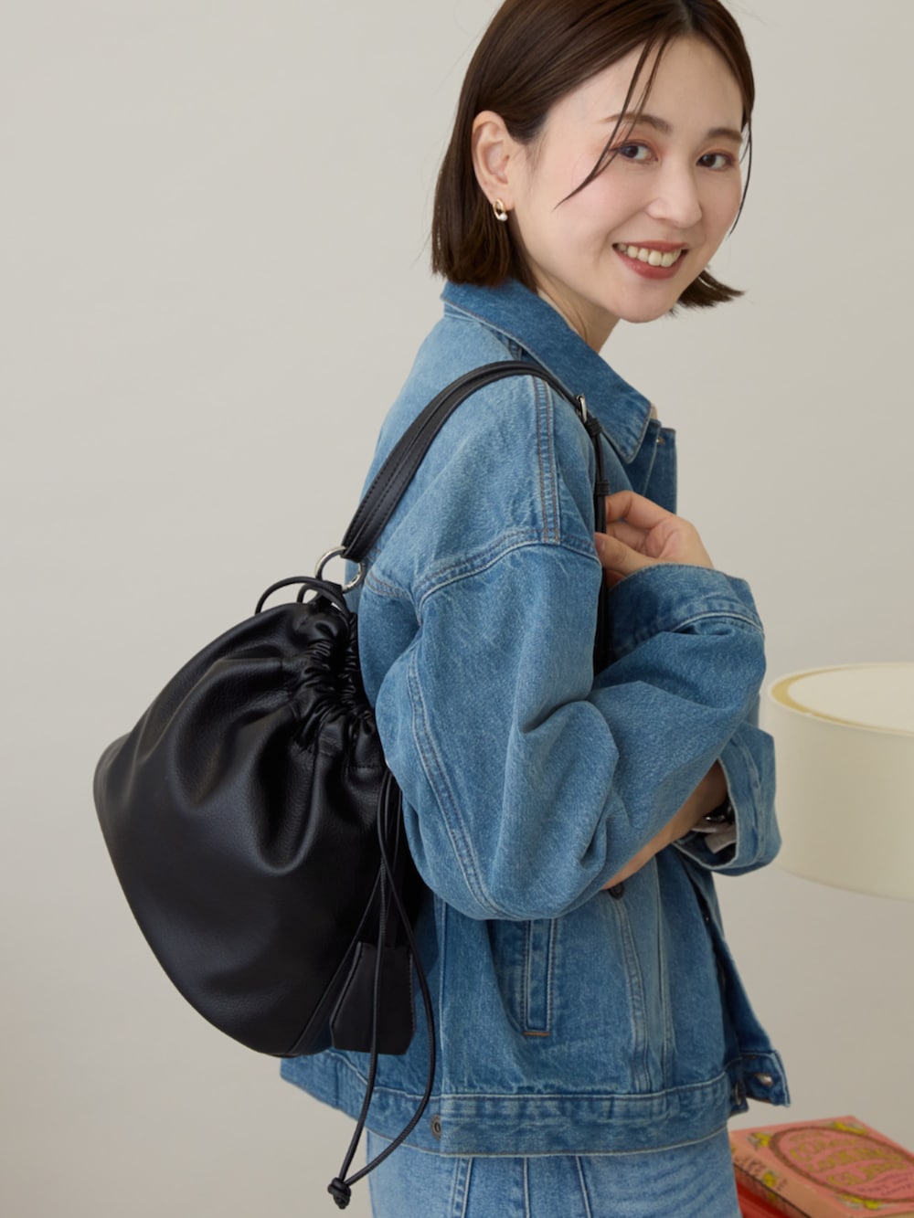 ブルー系のデニムジャケット、ブルー系のスカート、ブラック系のショルダーバッグを着用したレディースの冬コーディネートの4枚目の写真