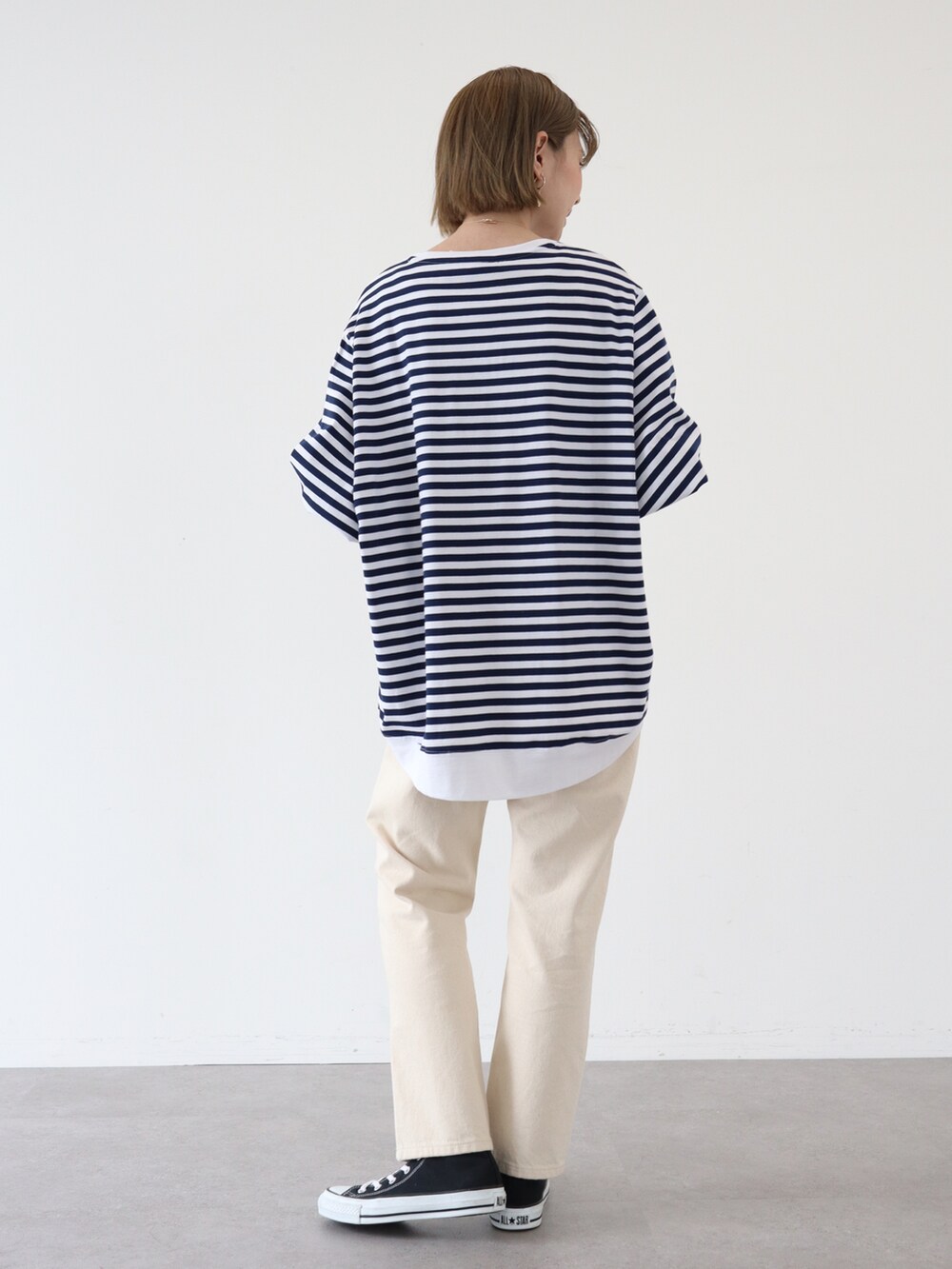 ベージュ系のデニムパンツ、ブルー系のTシャツ/カットソー、ゴールド系のピアス（両耳用）を着用したレディースの春コーディネートの3枚目の写真