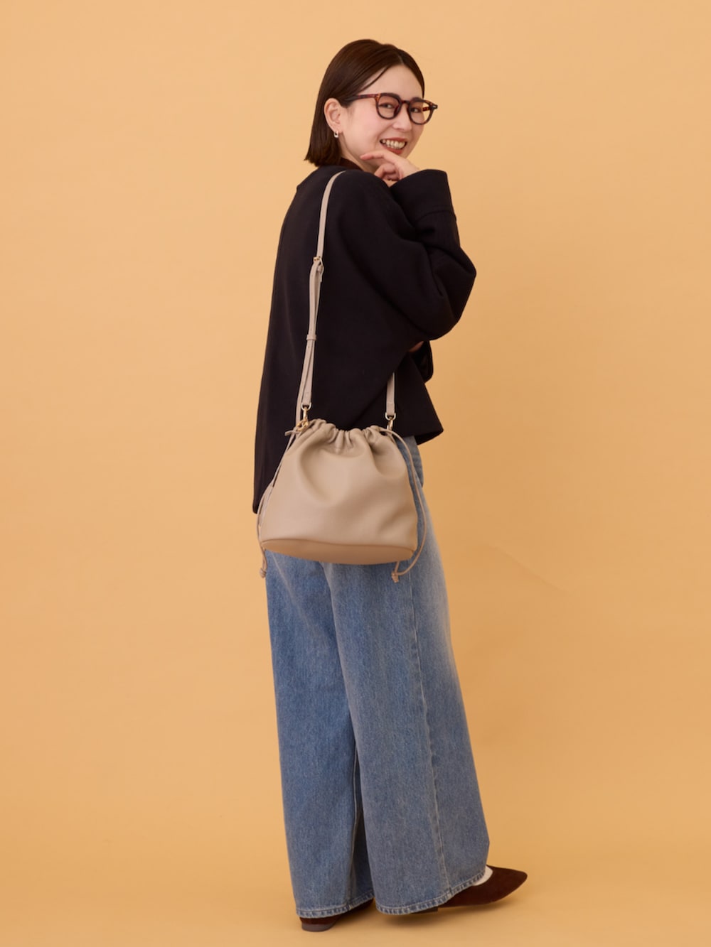 ブルー系のデニムパンツ、ブラック系のその他アウター、ブラウン系のニット/セーターを着用したレディースの冬コーディネートの3枚目の写真