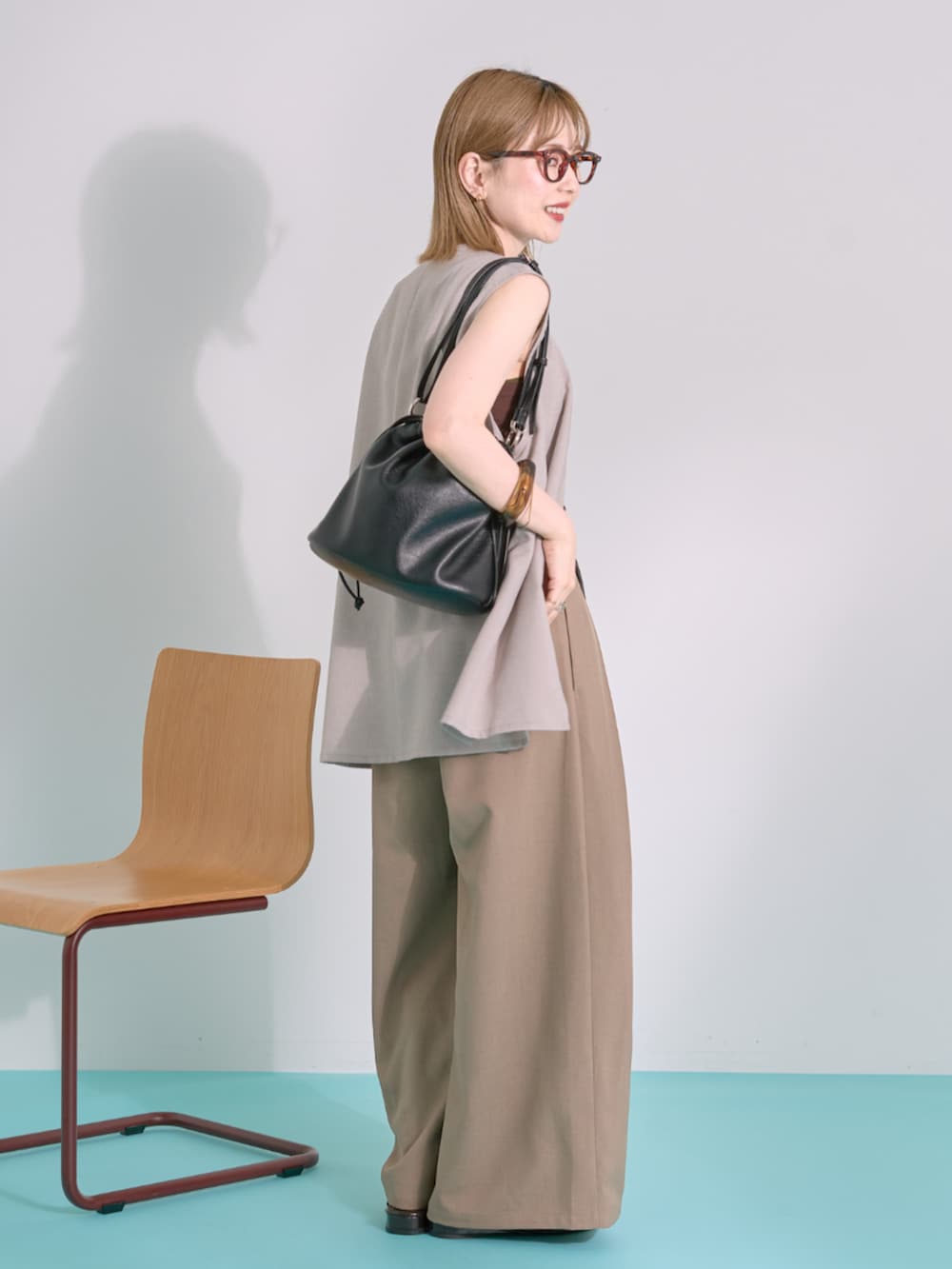 ブラック系のショルダーバッグ、ブラウン系のその他パンツ、ブラウン系のタンクトップを着用したレディースの夏コーディネートの2枚目の写真