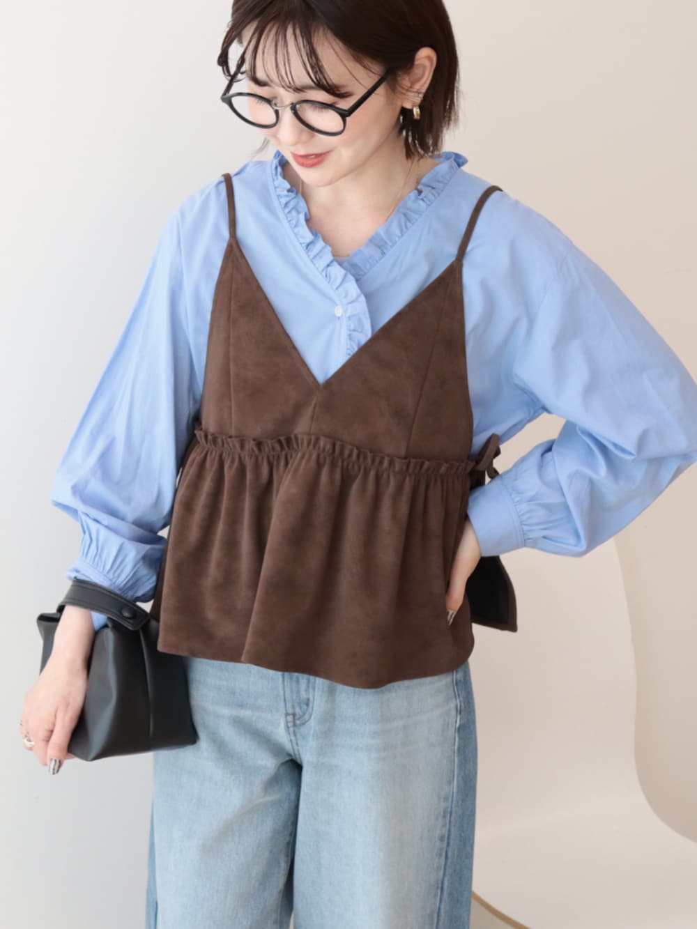 ブルー系のシャツ/ブラウス、ブラウン系のベスト、ブルー系のデニムパンツを着用したレディースの冬コーディネートの3枚目の写真