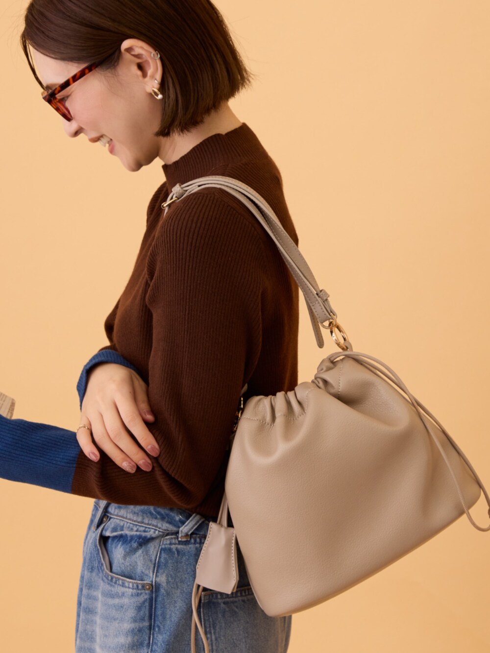 ブルー系のデニムパンツ、ブラック系のその他アウター、ブラウン系のニット/セーターを着用したレディースの冬コーディネートの5枚目の写真