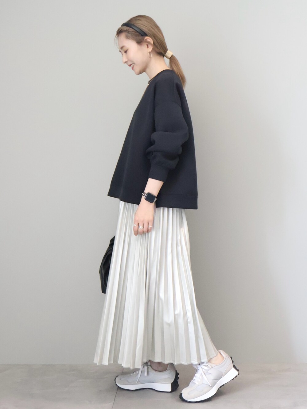 ブラック系のスウェット、シルバー系のスカート、ブラック系のハンドバッグを着用したレディースの秋コーディネートの4枚目の写真