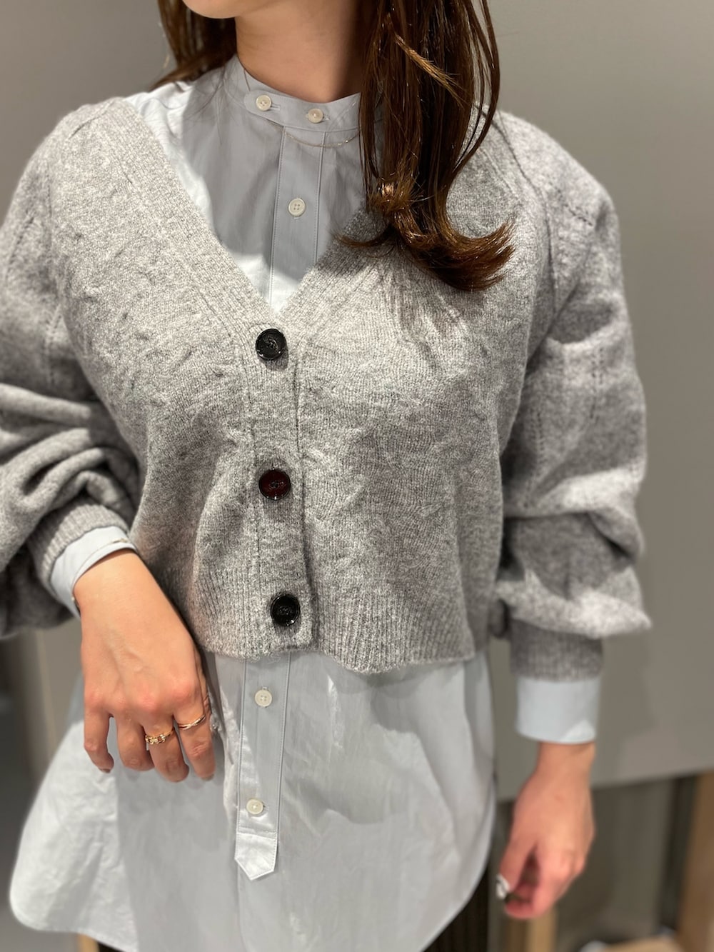 グレー系のカーディガン/ボレロ、ブルー系のシャツ/ブラウス、ブラウン系のスカートを着用したレディースの秋コーディネートの2枚目の写真