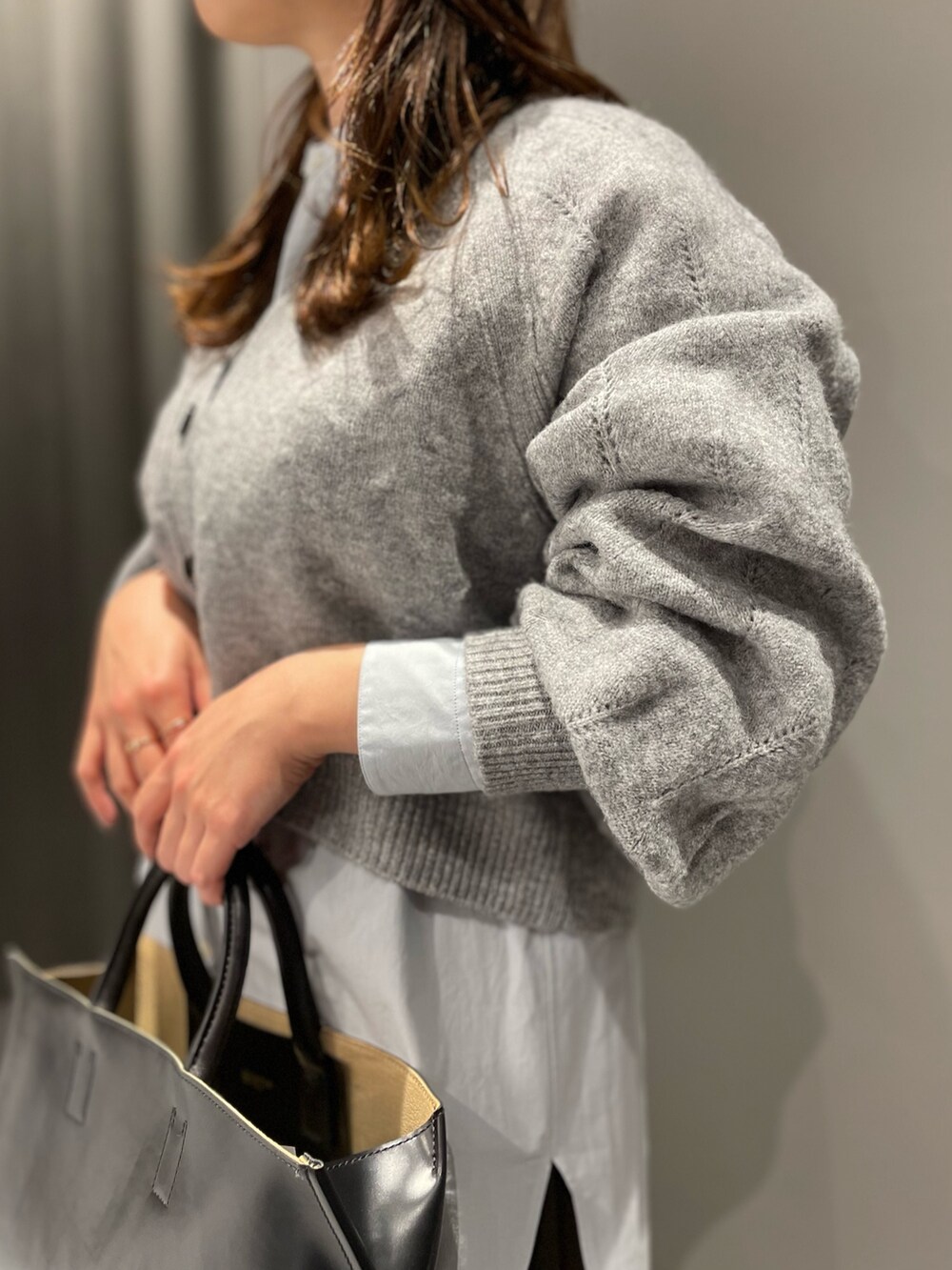 グレー系のカーディガン/ボレロ、ブルー系のシャツ/ブラウス、ブラウン系のスカートを着用したレディースの秋コーディネートの4枚目の写真