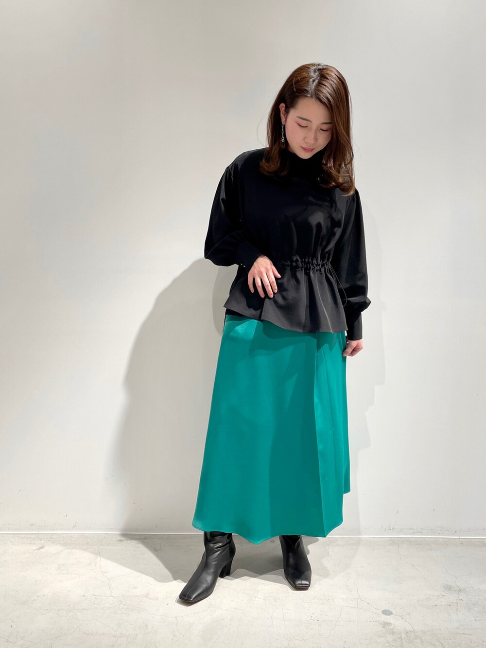 ブラウン系のブルゾン、ブラック系のシャツ/ブラウス、グリーン系のスカートを着用したレディースの冬コーディネートの2枚目の写真