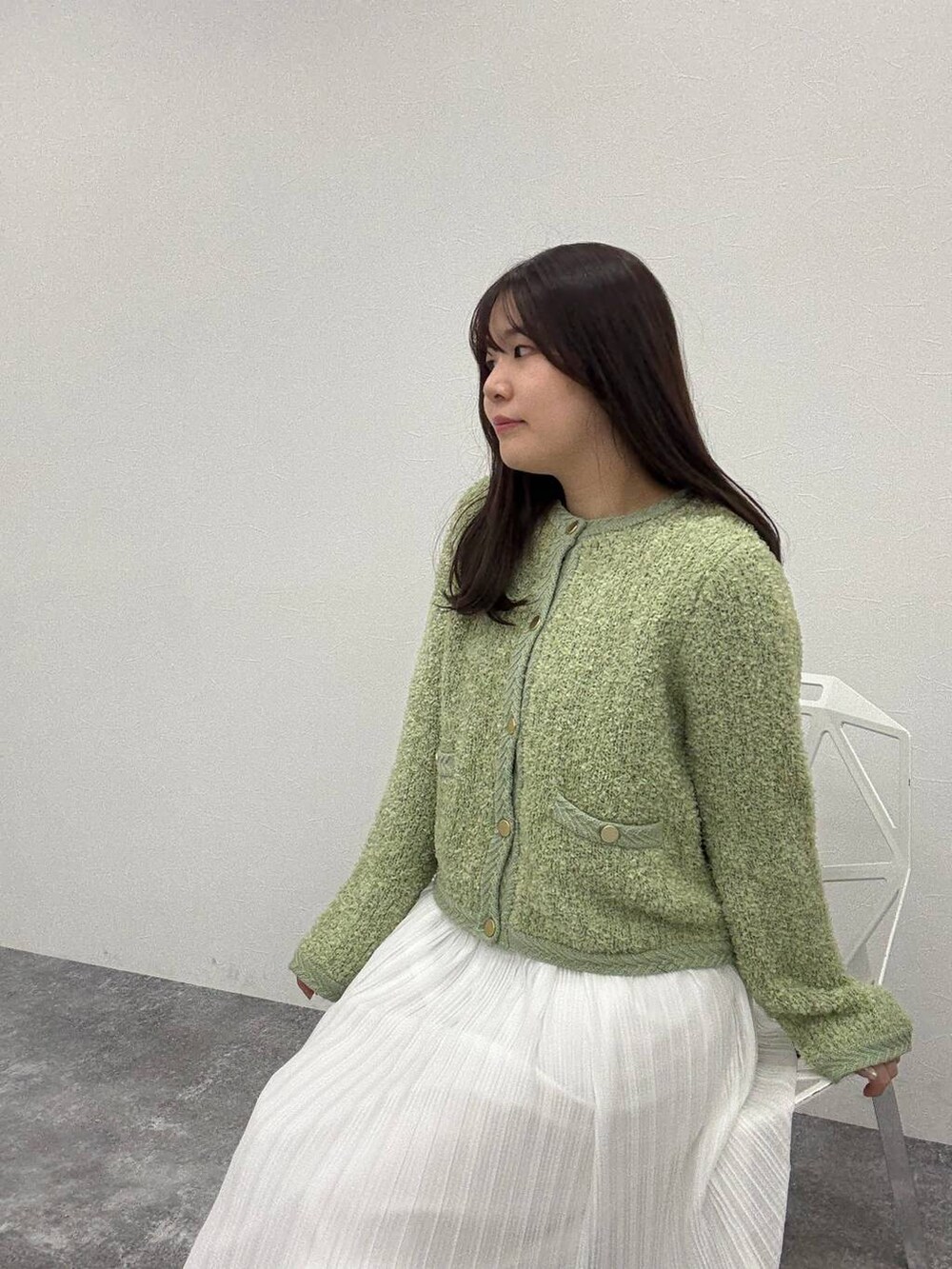 ベージュ系のパンプス、グリーン系のカーディガン/ボレロ、ホワイト系のスカートを着用したレディースの冬コーディネートの3枚目の写真