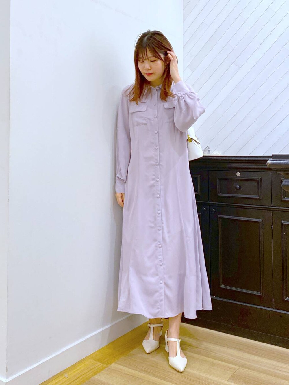 ホワイト系のショルダーバッグ、ベージュ系のワンピース、ホワイト系のパンプスを着用したレディースの春コーディネートの2枚目の写真