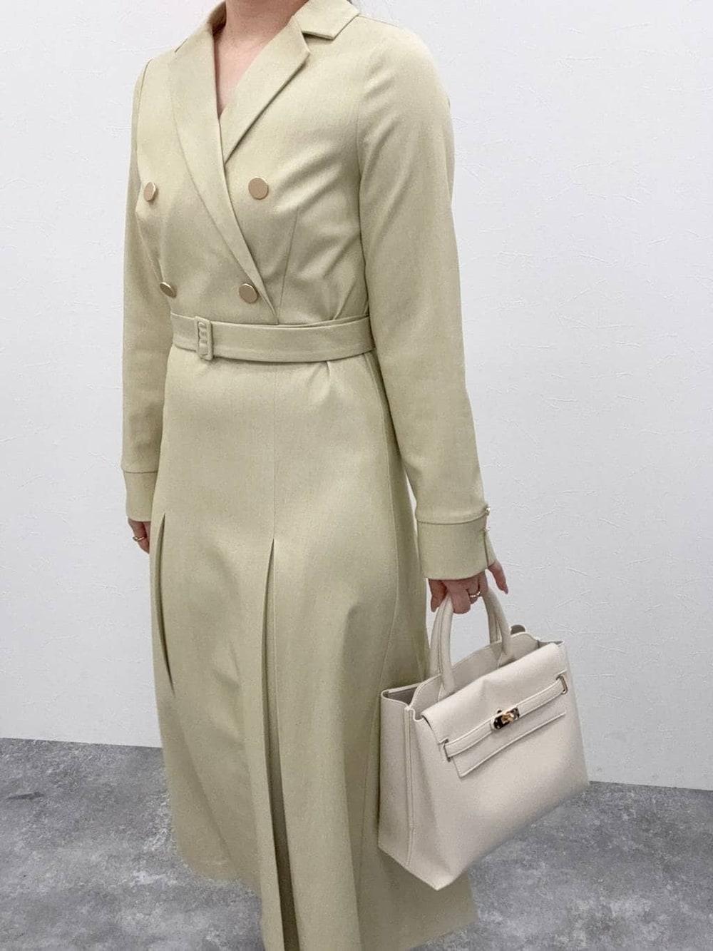 ホワイト系のトートバッグ、グリーン系のワンピースを着用したレディースの冬コーディネートの3枚目の写真