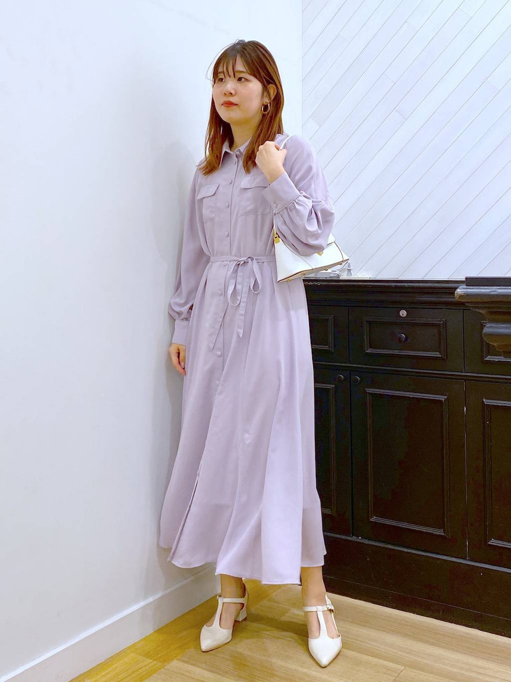 ホワイト系のショルダーバッグ、ベージュ系のワンピース、ホワイト系のパンプスを着用したレディースの春コーディネートの3枚目の写真