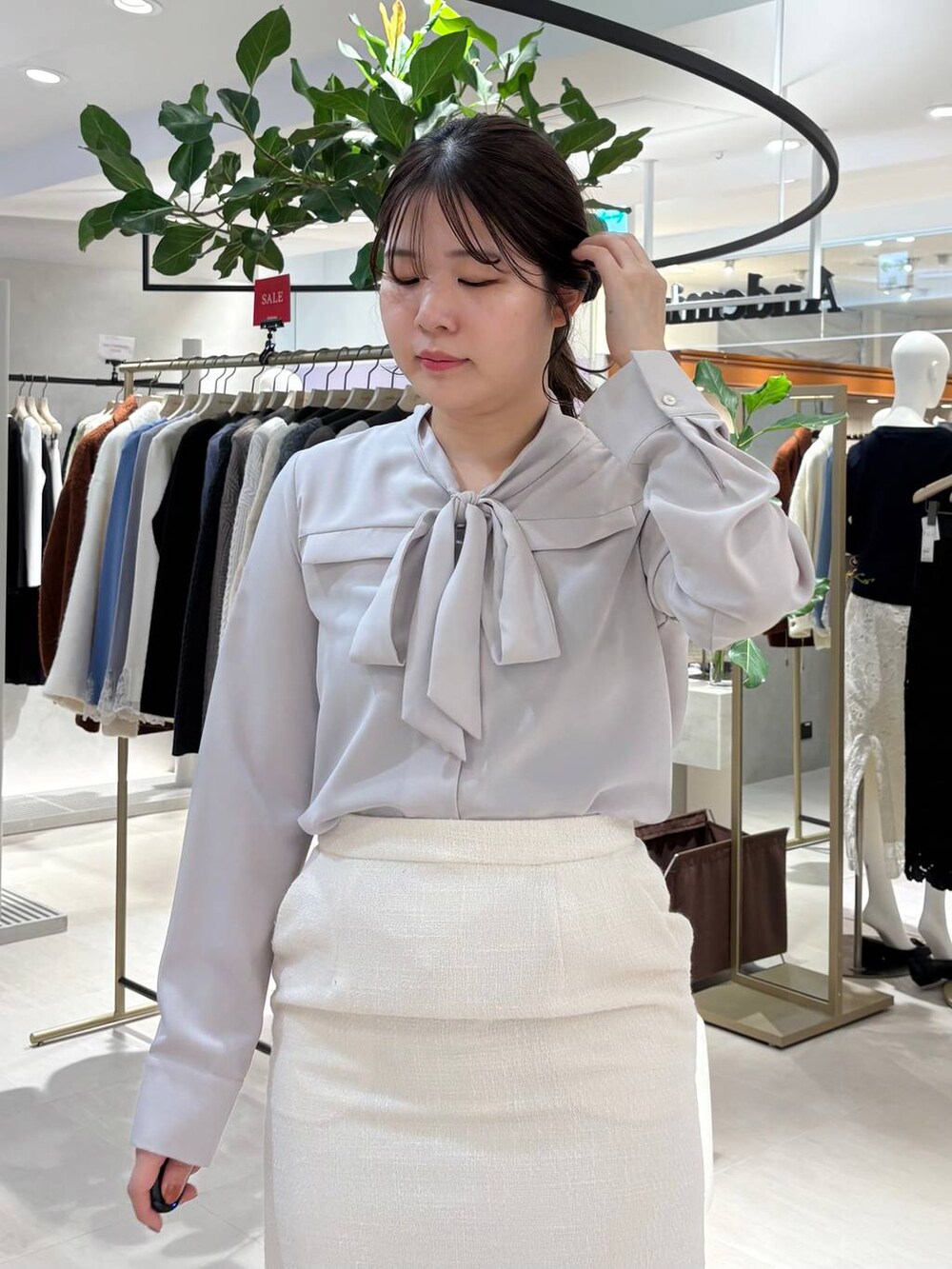 ブラック系のパンプス、ブラック系のトートバッグ、ホワイト系のテーラードジャケットを着用したレディースの春コーディネートの4枚目の写真