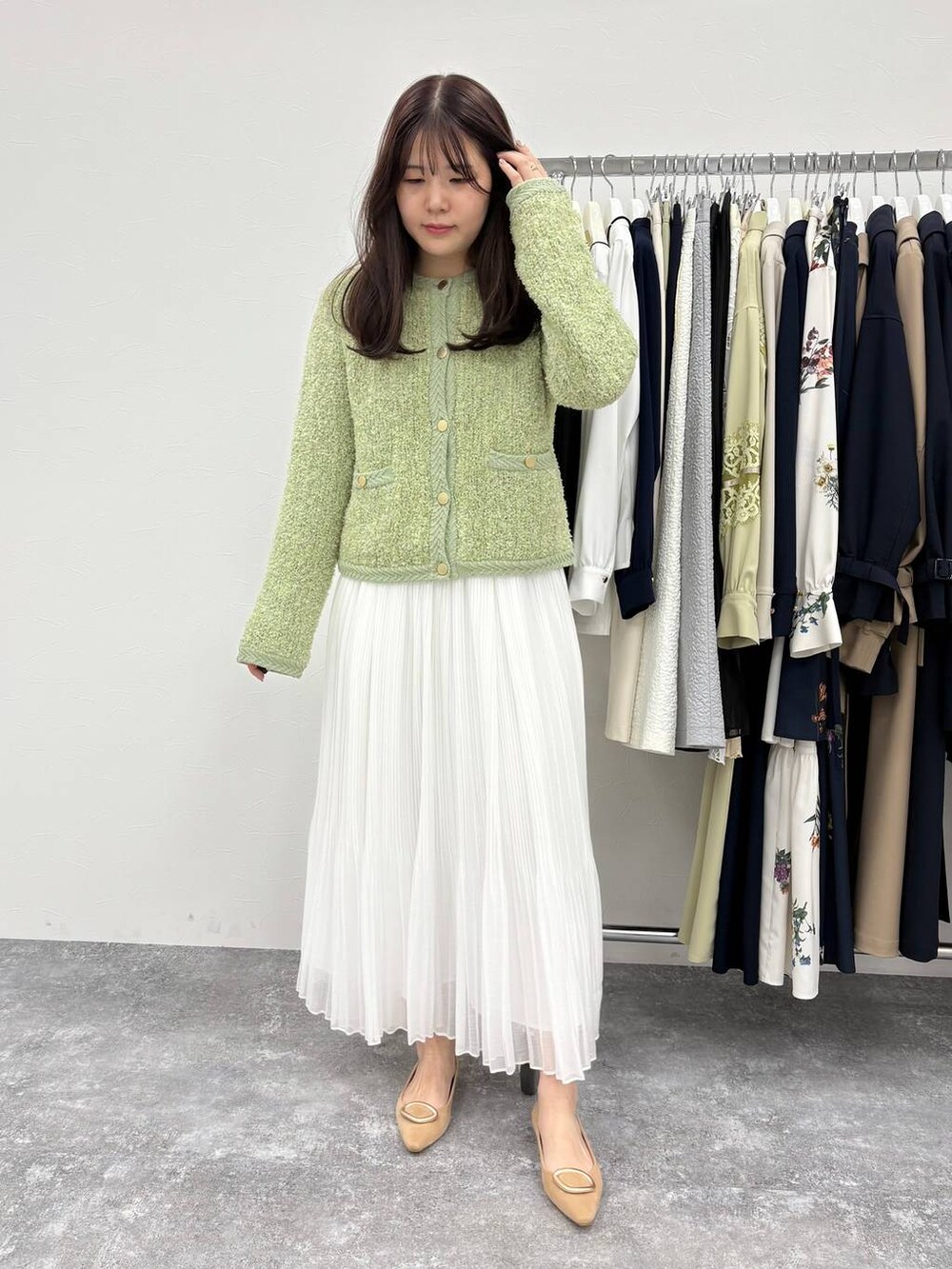 ベージュ系のパンプス、グリーン系のカーディガン/ボレロ、ホワイト系のスカートを着用したレディースの冬コーディネートの2枚目の写真