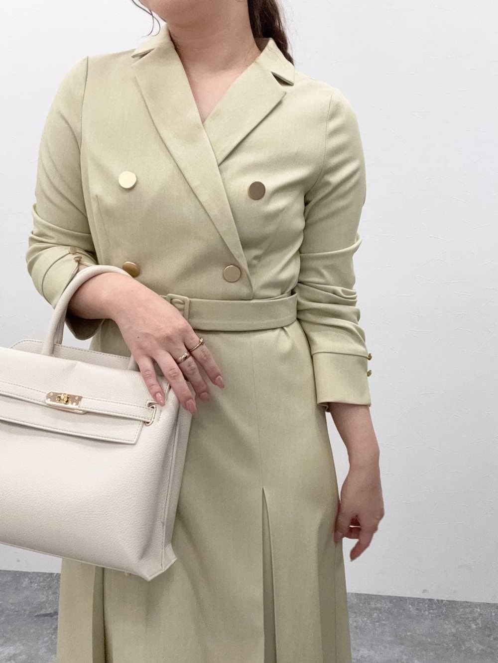 ホワイト系のトートバッグ、グリーン系のワンピースを着用したレディースの冬コーディネートの5枚目の写真