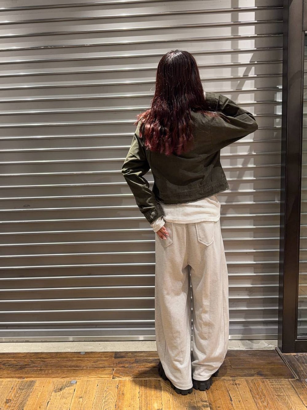グリーン系のノーカラーコート、ホワイト系のTシャツ/カットソー、ベージュ系のスウェットパンツを着用したレディースの秋コーディネートの4枚目の写真