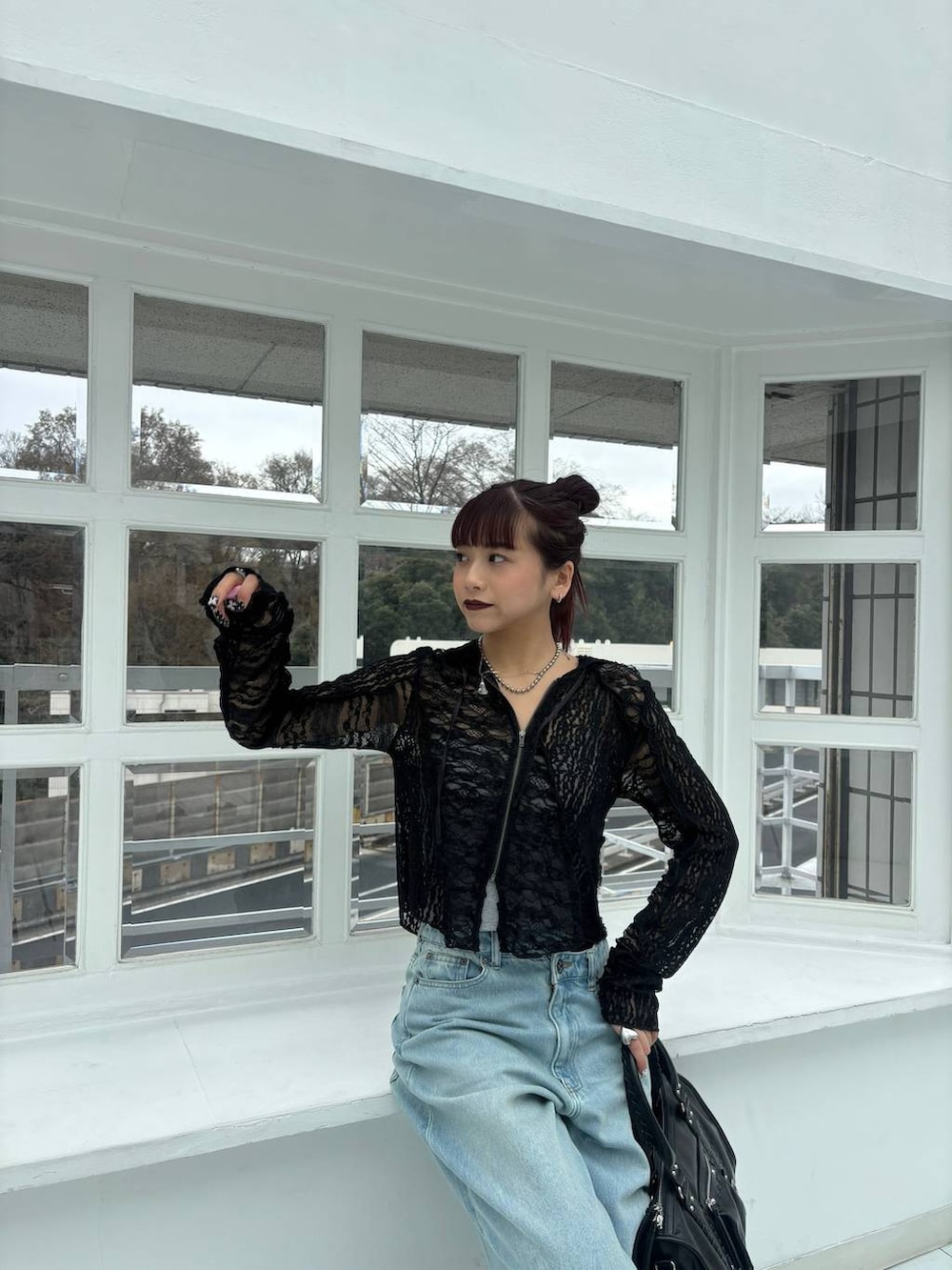 ブラック系のスニーカー、ブラック系のボストンバッグ、ブラック系のパーカーを着用したレディースの春コーディネートの5枚目の写真