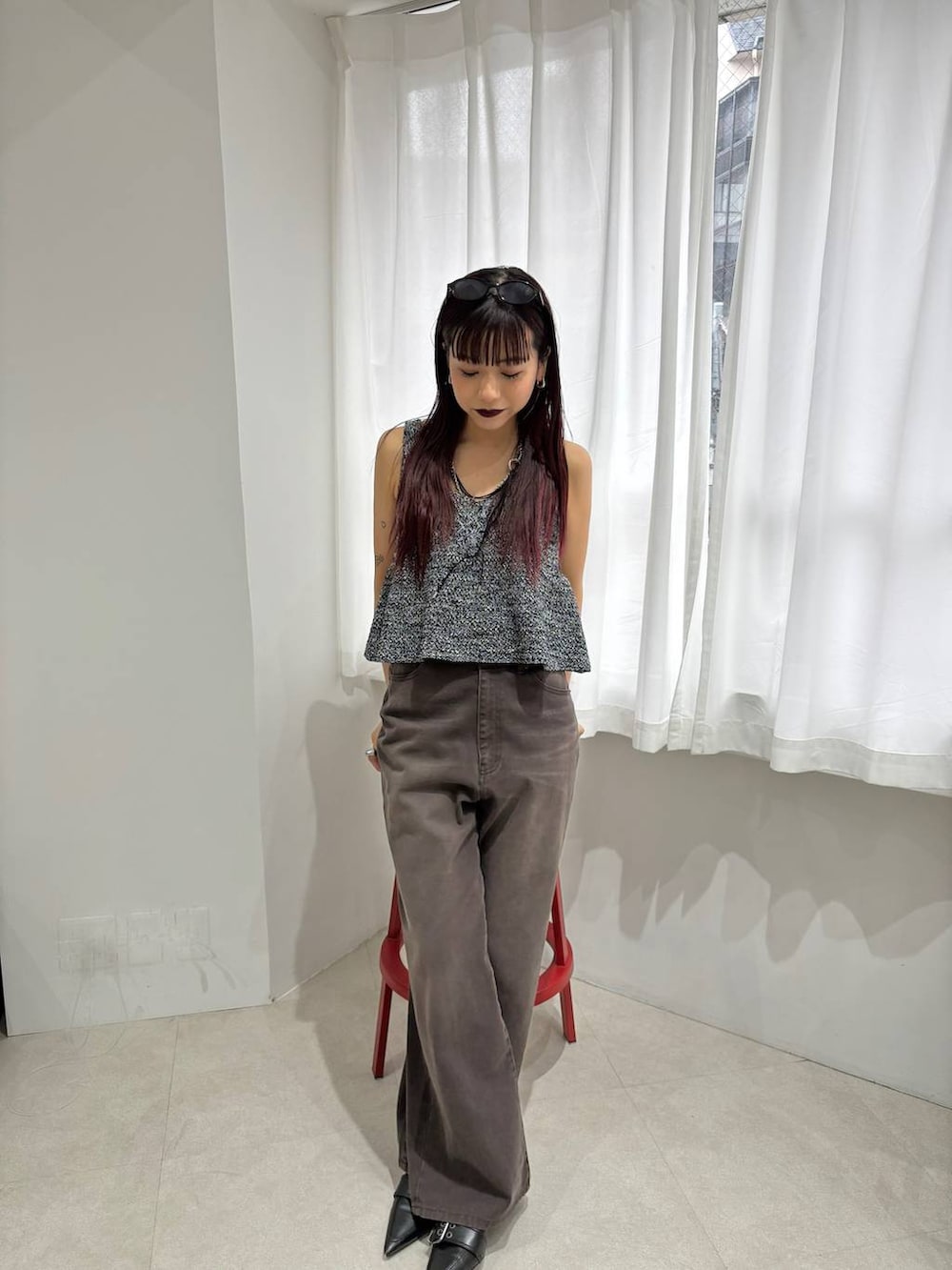 ブラック系のショルダーバッグ、ブラウン系のデニムパンツ、ブラック系のベストを着用したレディースの春コーディネートの2枚目の写真