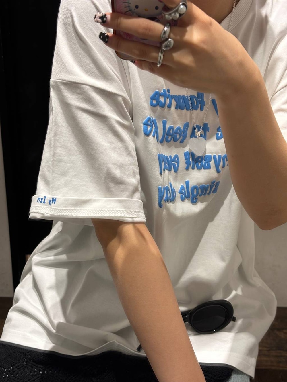 ブルー系のデニムパンツ、ホワイト系のTシャツ/カットソー、ブラック系のベルトを着用したレディースの春コーディネートの3枚目の写真