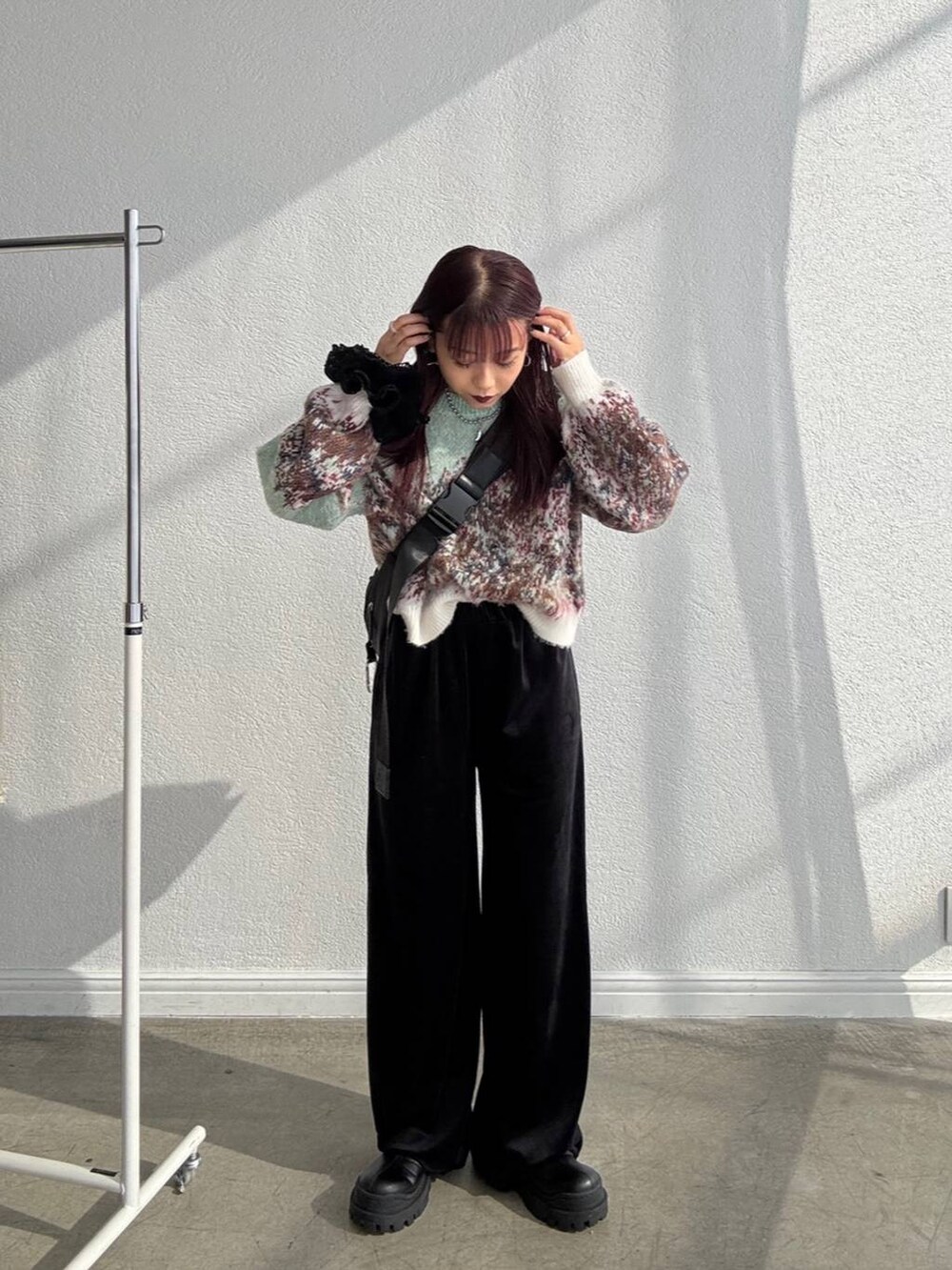 グレー系のショルダーバッグ、ブラック系のその他パンツ、グリーン系のニット/セーターを着用したレディースの秋コーディネートの2枚目の写真