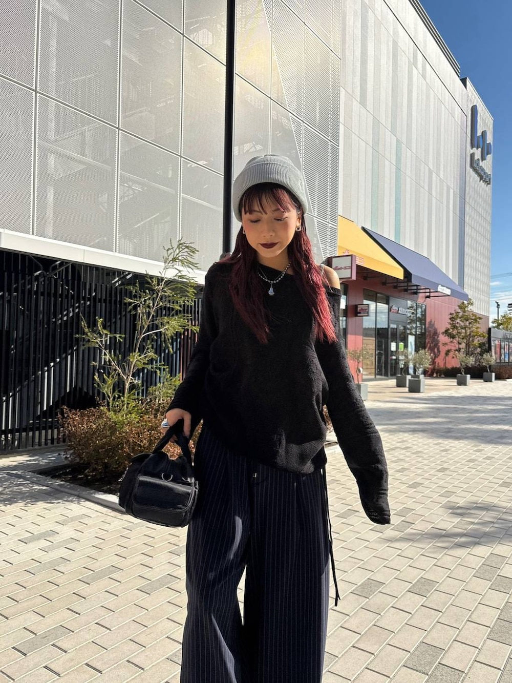 ブラック系のボストンバッグ、ブルー系のスラックス、ブラック系のニット/セーターを着用したレディースの春コーディネートの3枚目の写真