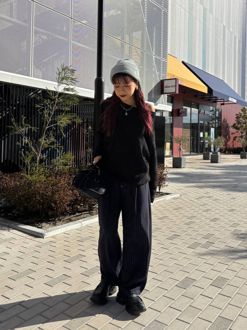 ブラック系のボストンバッグ、ブルー系のスラックス、ブラック系のニット/セーターを着用したレディースの春コーディネートの2枚目の写真