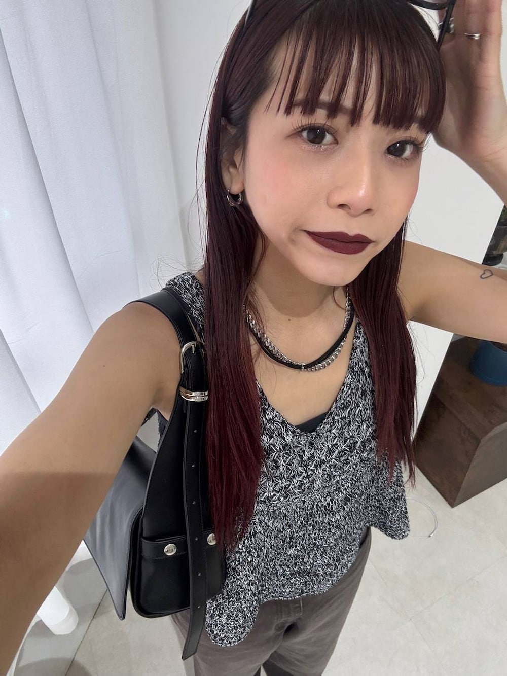 ブラック系のショルダーバッグ、ブラウン系のデニムパンツ、ブラック系のベストを着用したレディースの春コーディネートの6枚目の写真